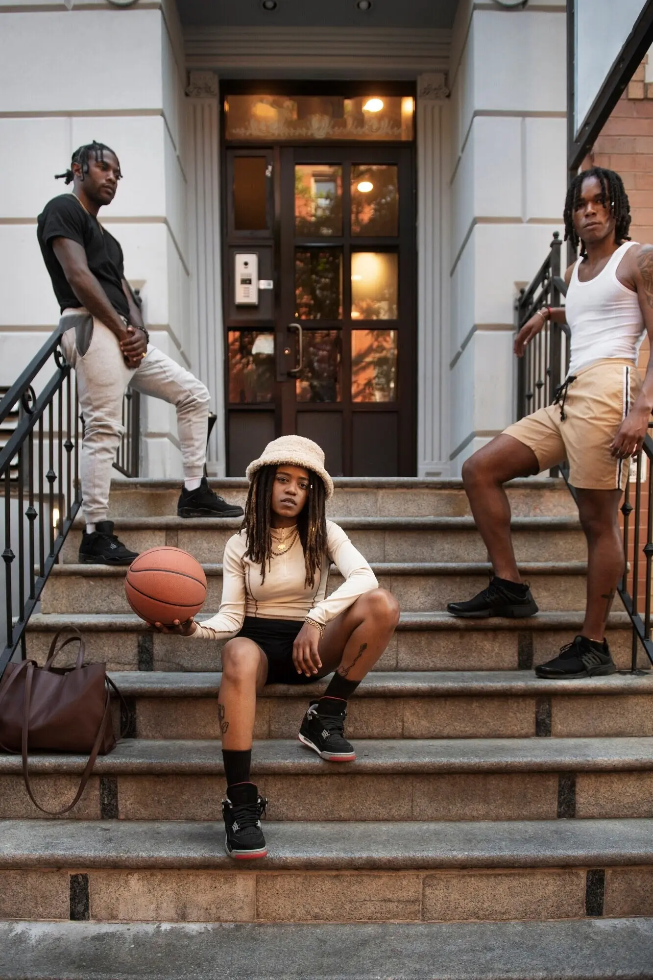 Ganzkörperaufnahme von Freunden, die auf einer Treppe posieren.